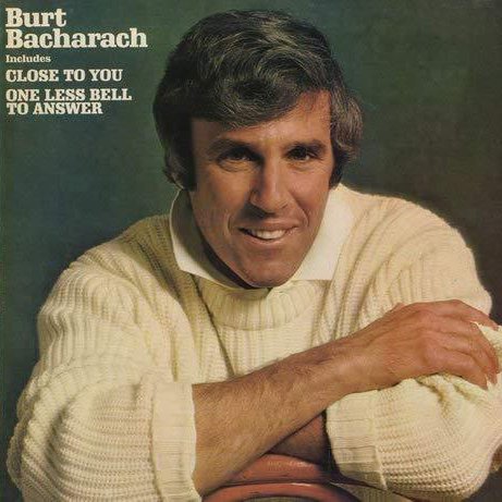 The album cover of Burt Bacharach's "Close to You" featuring Burt Bacharach wearing a cream sweater, smiling, with a green background.