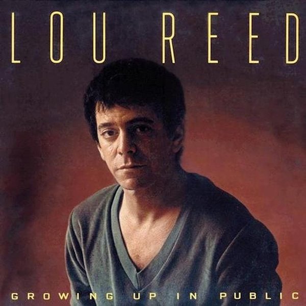 Album cover of Lou Reed's 'Growing Up in Public' featuring a portrait of Lou Reed with a serious expression, wearing a V-neck shirt against a red and brown background.